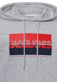 Sudadera gris con cordones, que presenta un atrevido diseño gráfico en rojo y azul marino. El texto incluye "JACK&JONES" y "CREATIVE STUDIO EN DINAMARCA".