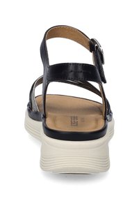 Czarne skórzane sandały z dwoma regulowanymi paskami, wyściełaną w tanie wkładką oraz białą podeszwą platformową z delikatnym żłobieniem.