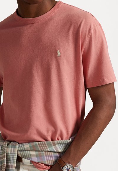 Korte mouwen crewneck t-shirt in lichtroze katoen, met een klein geborduurd logo op de borst, gecombineerd met een geblokte flanellen stof rond de taille.