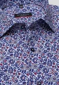 Bomullsskjorta har ett blått blommönster med röda och beige detaljer. Inkluderar krage med knappar och mörka knappar. Modern passform.