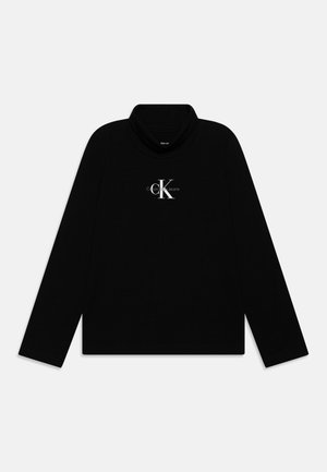Czarna koszulka z długim rękawem i golfem z białym logo „cK Calvin Klein Jeans” na środku klatki piersiowej.