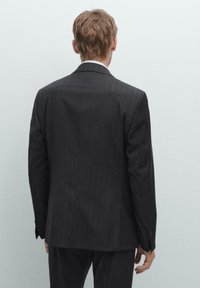Schwarze Nadelstreifen-Anzugjacke mit Reverskragen und einem Knopf, aus strukturiertem Stoff mit glatter Oberfläche.