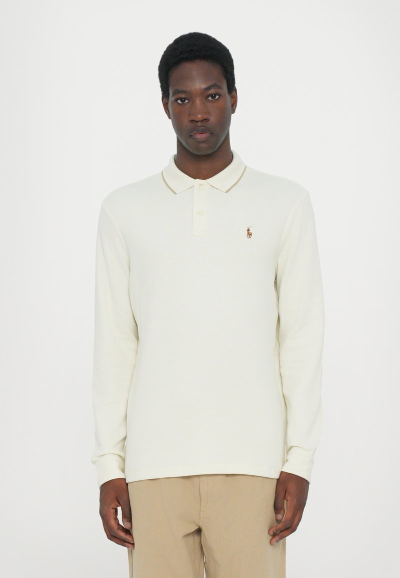 Polo cu mânecă lungă în off-white, cu un material texturat subtil, având un guler în contrast și un logo brodat mic pe piept.