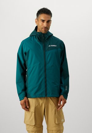 Teal waterdichte jas met een rits aan de voorkant en een verstelbare capuchon. Kenmerkt subtiele branding op de borst en mouw. Lichtgewicht materiaal met een gladde textuur.