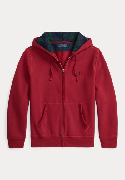 Sweatshirt vermelha com fecho éclair e bolso frontal, com capuz forrado em tecido xadrez verde e azul. Logótipo na área do peito esquerdo. Textura de tecido macio.