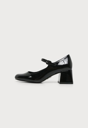 Chaussure Mary Jane en cuir verni noir avec bout arrondi, petit talon bloc et bride réglable à boucle sur fond uni.