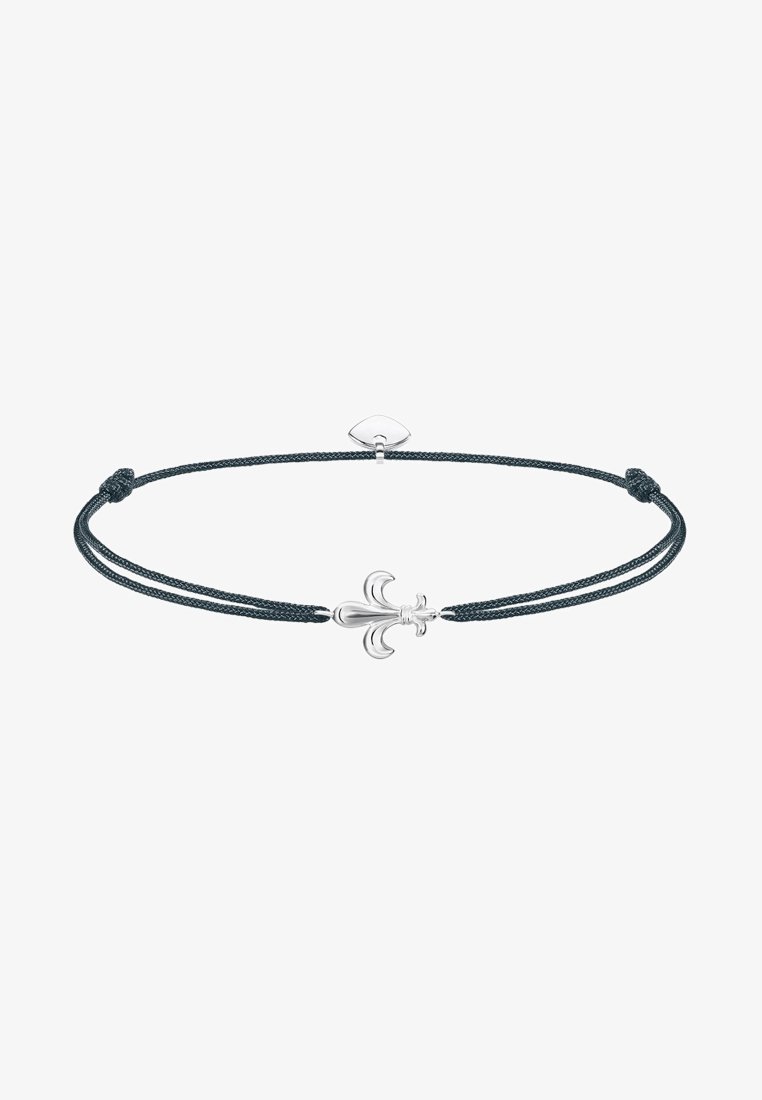 Bracelet cordon noir ajustable avec un charm fleur-de-lis en argent centré et un petit cœur en argent près du fermoir.
