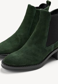 Grüne Wildleder-Stiefeletten mit elastischen Seitenpaneelen, runder Zehenpartie und strukturierten schwarzen Mesh-Akzenten. Mit einer schwarzen Gummisohle und gesteppten Details.