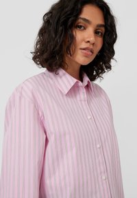 Light pink striped shirt with a collared neckline, button front, and cuffed sleeves. Subtle green and white stripes throughout.