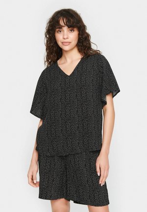 Sæt bestående af sort kortærmet top og shorts med V-hals og hvidsprækket mønster. Blødt, let stof med en afslappet pasform.
