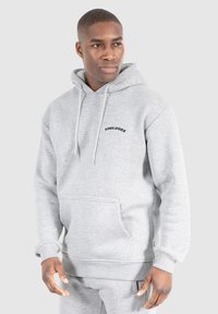 Grauer Kapuzenpullover mit einer vorderen Kängurutasche, elastischen Bündchen und schwarzem "SMILODOX"-Text auf der Brust. Weicher Stoff, lässiges Design.