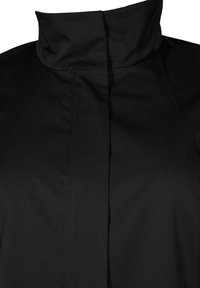 Black high-collared jacket with a smooth texture and sleek design. Features vertical seams and a minimalistic style. No visible hardware.