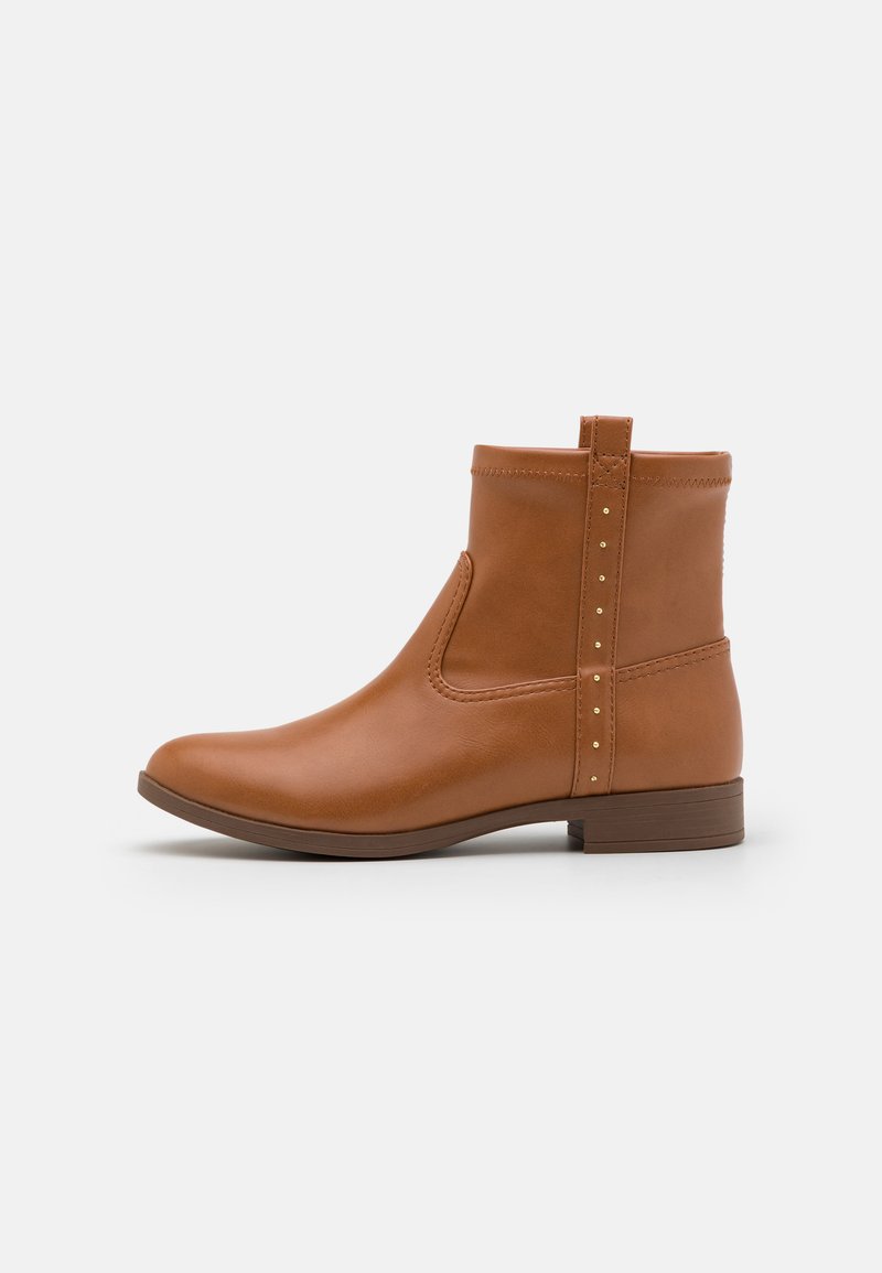 Botte de cheville en cuir marron avec une texture lisse, un panneau élastique sur le côté et des clous dorés à l'arrière, dotée d'un petit talon carré.