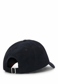 Marineblå kordfløjlsbaseballkasket med en rund krone, justerbar rem og en buet skygge. Har lufthuller til ventilation.
