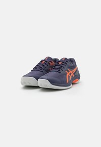 Încălțăminte sportivă de navy cu un superior din plasă texturată, accente portocalii și o talpă albă cu un model de aderență pentru tracțiune.