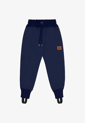 Granatowe dziecięce spodnie dresowe z elastycznym pasem, sznurkiem, ściągaczami na końcach nogawek i paskami na stopy, z małą brązową naszywką z logo po boku.