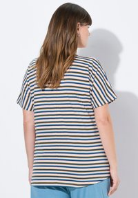 T-shirt a righe con maniche corte, con strisce verticali blu, verde, giallo e rosa su uno sfondo chiaro. Tessuto dalla superficie liscia.