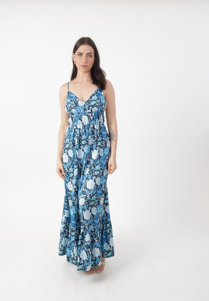 Robe maxi florale avec des motifs de roses bleues et blanches, bretelles spaghetti réglables et taille froncée. Le tissu a une texture douce.