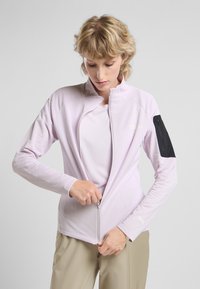 Lichtpaarse zip-up jacket met een hoge kraag, geribbelde textuur en een zwarte ritszak op de linkermouw.