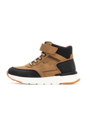 Zapatillas de media caña marrón de ante y negro sintético con una suela blanca, que presentan una correa de velcro y detalles en naranja, texturizadas para ofrecer agarre.