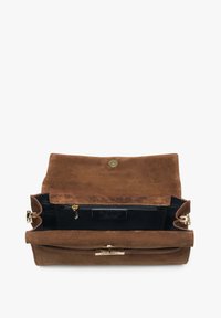 Brown suede handbag with a flap closure and gold hardware. Interior features a zip pocket and a black lining.