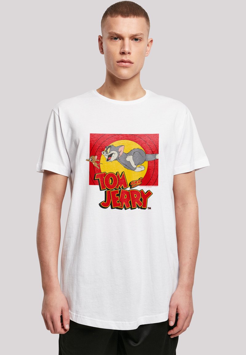 White cotton t-shirt featuring a colorful "Tom and Jerry" graphic, with a cartoon cat and mouse, set against a red and yellow background.