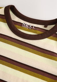 Gros plan d'un col de t-shirt rayé avec bordure marron et rayures horizontales dans des tons beige, marron et vert olive avec étiquette "NEXT Essential Tee".