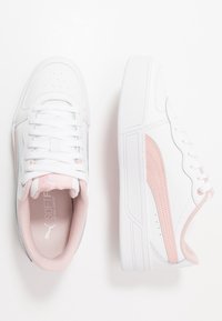 Białe sneakersy z różowymi akcentami, wykonane z materiału syntetycznego. Posiadają okrągły nosek, wyściełany język i perforowane detale po bokach.