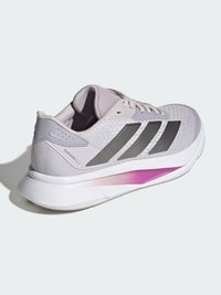 Svetlofialová športová obuv s hornou časťou z sieťoviny, sivým dizajnom s tromi pruhmi a podrážkou bielej farby s ružovým nádychom. Obsahuje polstrovaný golier a ľahkú konštrukciu.