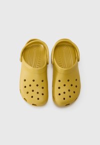 Yellow rubber clogs with multiple ventilation holes, a rounded toe, and a back strap for secure fit. Smooth matte texture.