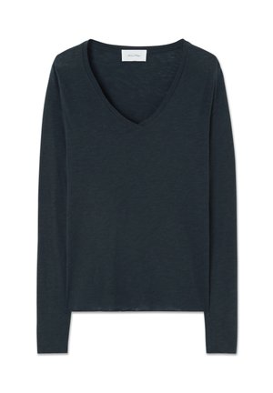 Tumši zils, garām piedurknēm, V veida izgriezuma viegls krekls ar pieguļošu formu un mazu baltu etiķeti apkakles iekšpusē.