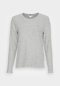 Grå ribbad tröja med långa ärmar och rund halsringning. Har en liten broderad logotyp på bröstet. Mjuk stickad textur.