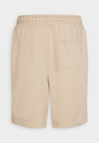 Shorts beiges avec une taille élastique, dotés d'une poche arrière et d'une texture douce et lisse. Ourlet fini avec un double surfilage.