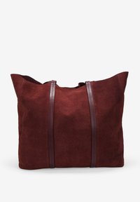 Bolso de tote de ante en burdeos profundo con dos asas de cuero texturizado. Diseño espacioso, superficie suave y amplia abertura para un fácil acceso.