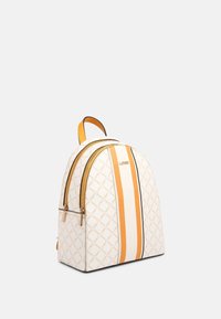 Sac à dos blanc avec un motif en diamant, des rayures orange et blanches, des accents dorés, et une texture lisse avec des doubles zips.