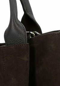 Borsa in suede marrone con manici in pelle testurizzata. Presenta un portachiavi in metallo all'interno e cuciture pulite attorno alla parte superiore aperta.