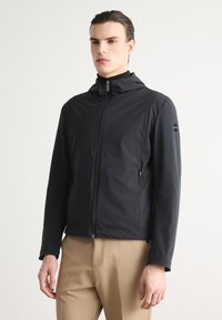 Black hooded jacket with a zip closure, featuring a smooth, matte texture and a logo patch on the left sleeve. Fitted design with pockets.