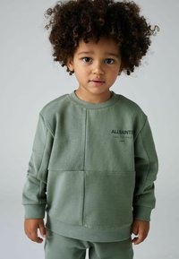 Sudadera verde con un diseño texturizado de patchwork. Presenta puños y cuello acanalados, y un logo en el pecho.