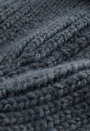 Mörkgrå stickad tyg med ett texturerat mönster, som visar tjocka och tunna garner invävda för ett mysigt utseende.