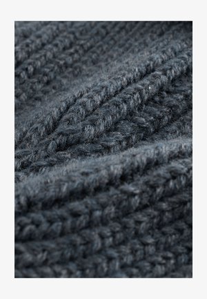 Mørkegråt strikket stof med et tekstureret mønster, der viser tykke og tynde garn sammenvævet for et hyggeligt udseende.