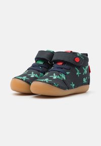 Chaussures pour tout-petits bleu marine avec motif de feuilles de palmier vertes, fermeture Velcro et semelle en caoutchouc. Présente des accents rouges et verts sur les sangles.