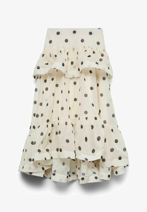 Krémréteges szoknya fekete pöttyökkel, rétegezett fodrokkal és áramló, aszimmetrikus szegéllyel.