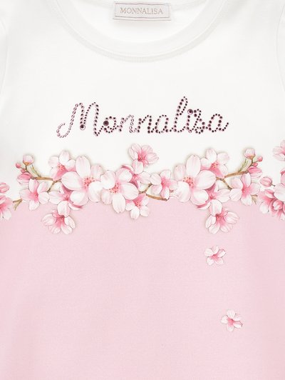 Top blanco de manga corta con estampado floral rosa y "Monnalisa" en strass. Tejido suave; fondo en degradado rosa con acentos florales.
