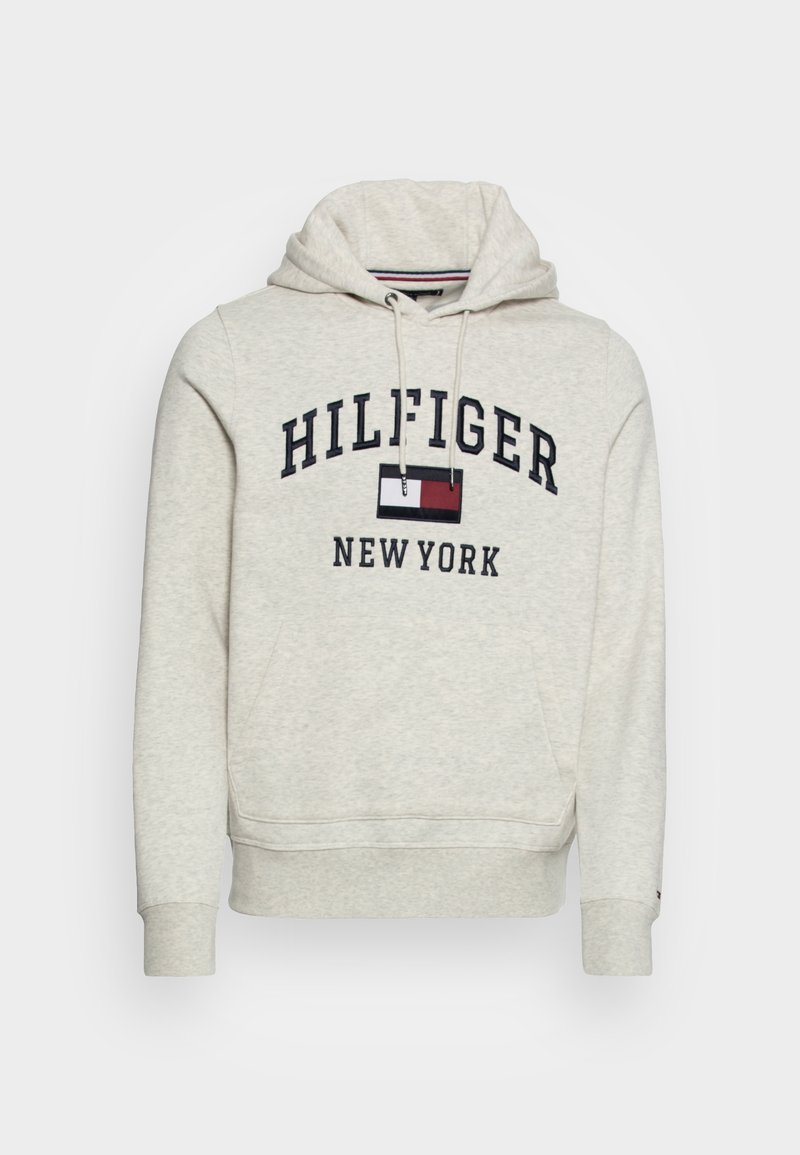Sweat à capuche gris clair avec poche frontale, cordons et texte "Hilfiger New York" avec un logo rectangulaire rouge, blanc et bleu sur la poitrine.