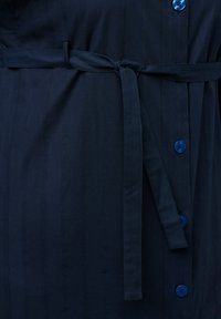 Abito blu navy con chiusura a bottoni sul davanti, bottoni blu e cintura in tessuto coordinato. Il tessuto presenta una sottile texture a righe verticali.