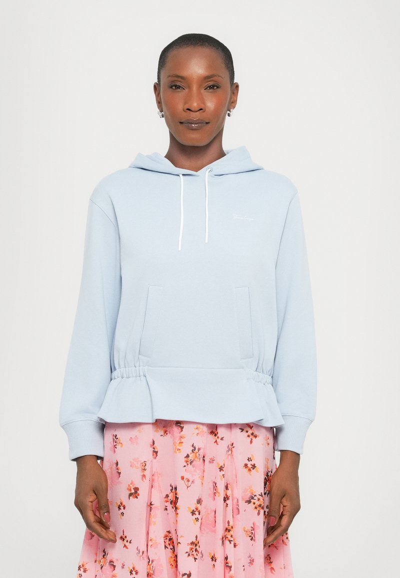 Light blue hoodie with a cinched waist, two front pockets, and white drawstrings. Features soft fabric and minimalistic design elements.