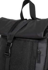Svart rull-top ryggsäck med texturerad nylon tyg, justerbara remmar och ett säkert spänne. Har en sidoficka med blixtlås för enkel åtkomst.