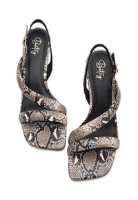 Schwarze, beige und graue High Heels mit Schlangenhautmuster. Sie verfügen über überkreuzte Riemen und ein quadratisches Zehendesign. Geschlossener Rücken mit Schnalle.