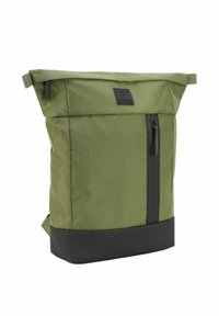 Mochila de tela verde con diseño de rollo en la parte superior, fondo negro, bolsillo frontal con cremallera y material texturizado. Presenta una etiqueta de marca en la parte delantera.