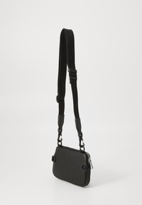 Black textured leather crossbody bag with adjustable strap and metal hardware; rectangular shape and zip closure detail.